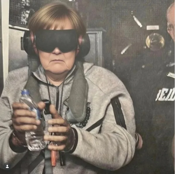 KI-generiertes Bild, auf dem Angela Merkel mit verbundenen Augen und Ohrschützern in einer Art Container sitzend zu sehen ist. Sie trägr eine graue Jacke und hält eine Wasserflasche in der Hand. Neben ihr steht eine halb im Bildrahmen sichtbare Person.
